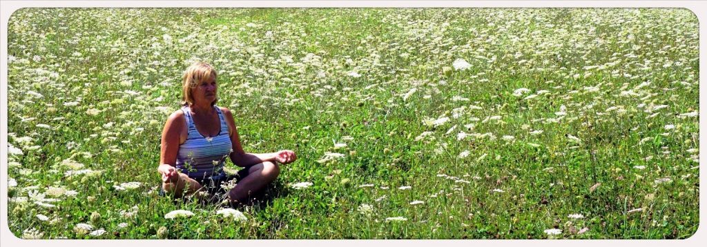 Lyn meditating in field Spain